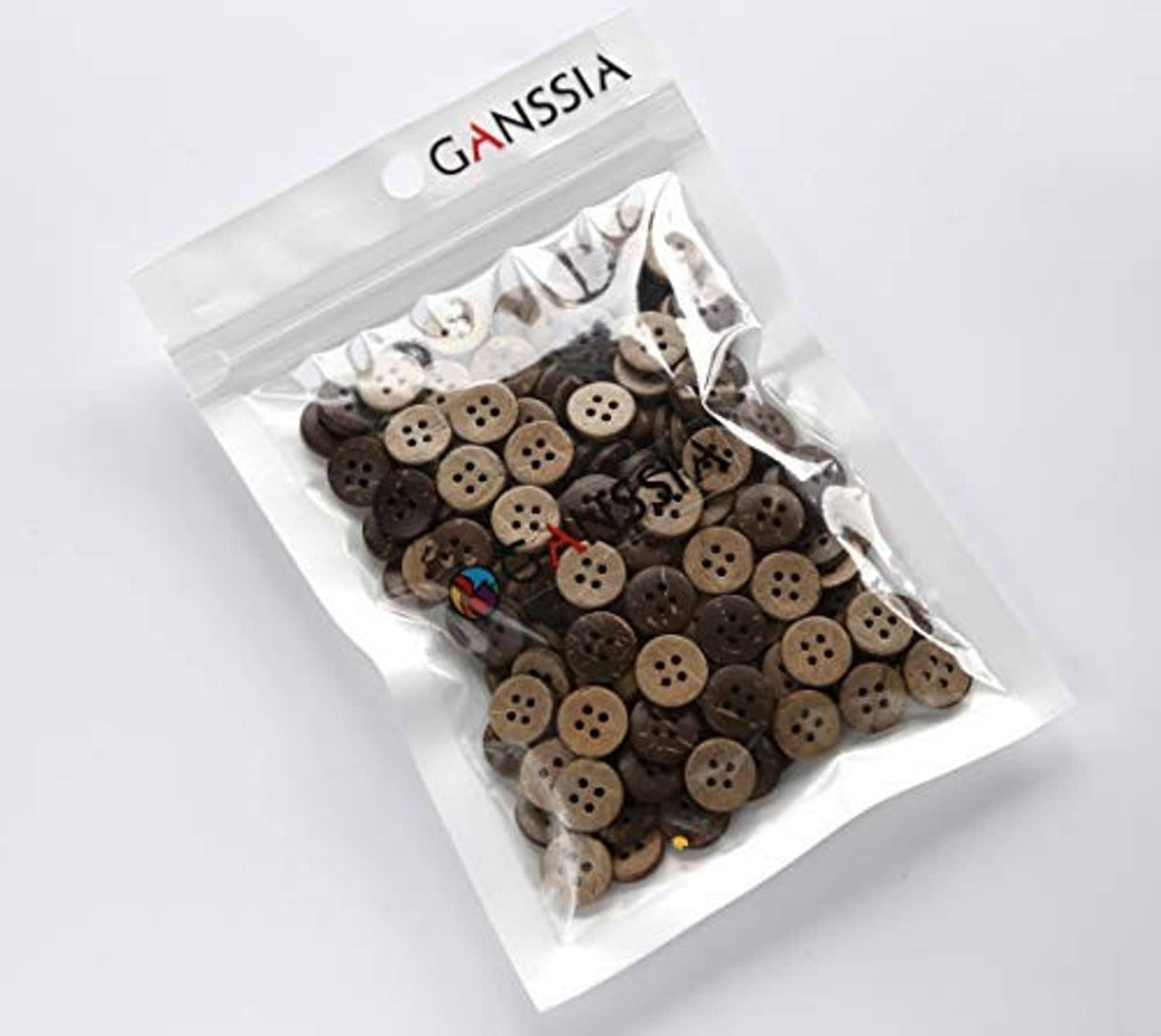 Ganssia bag of coconut shell buttons, round 4-hole buttons visible through clear pouch