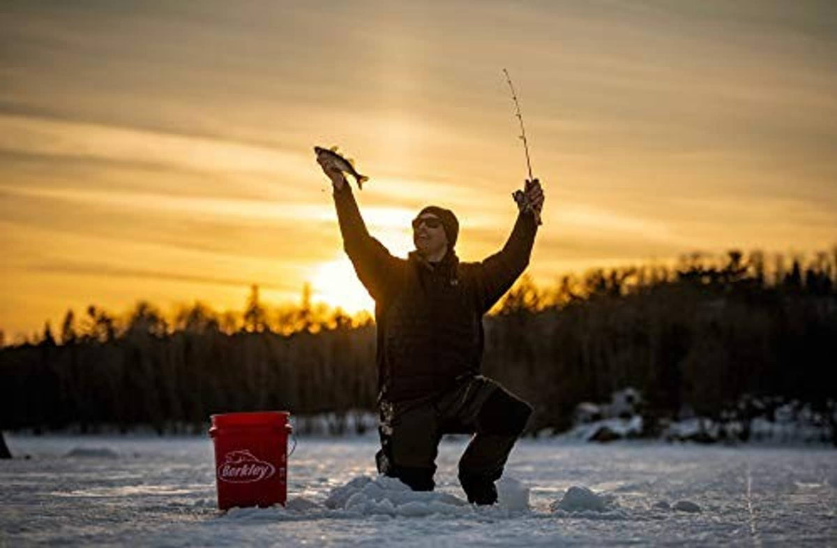 Ice fishing angler holding rods with fishing lines above the ice