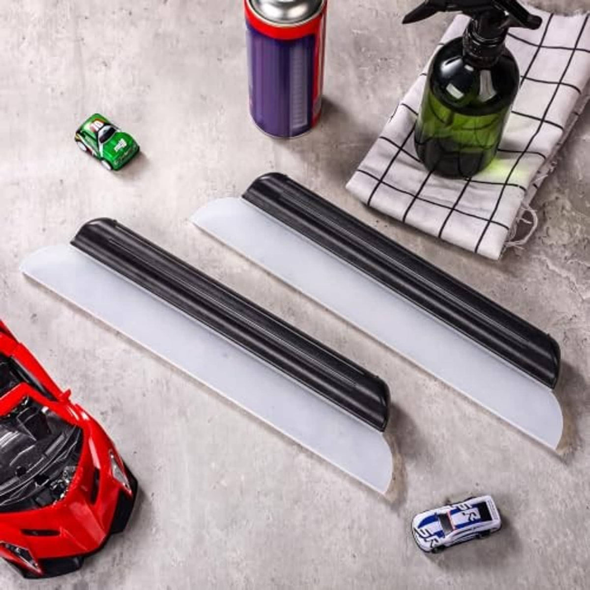 Car drying squeegee tools with black silicone blades, two long squeegees on surface
