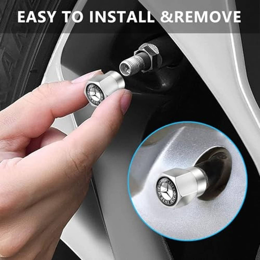 Silver tire valve stem cap being installed on a car wheel valve stem