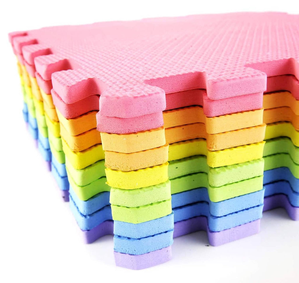 Stacked interlocking foam mat tiles in pink, yellow, green, and blue