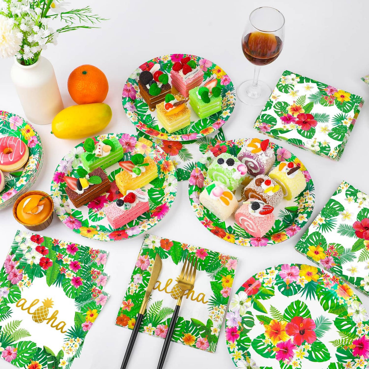 Tropical paper plates and napkins, green leaves with colorful flowers and 'aloha' text