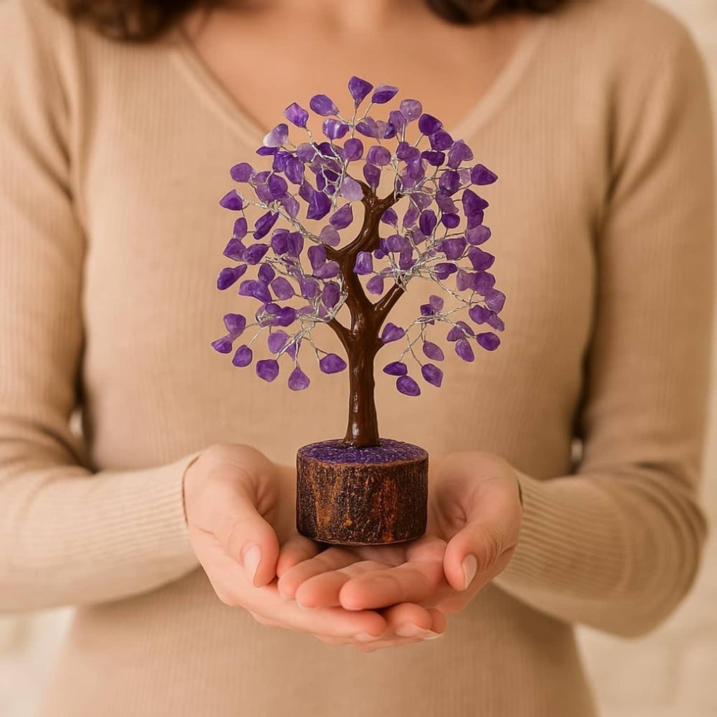 Amethyst crystal tree decoration held in hands, purple gem leaves on round wooden base