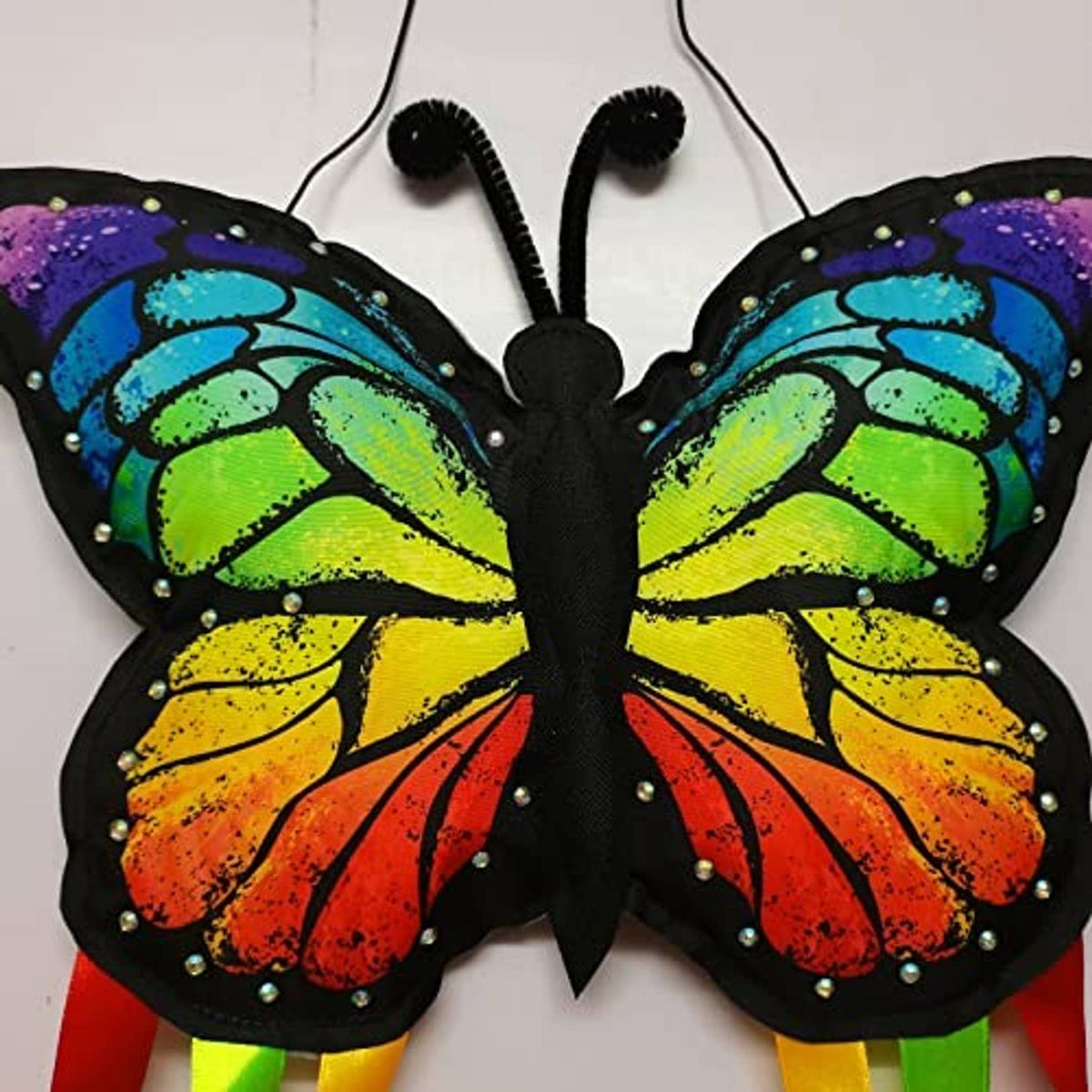 Close-up butterfly windsock with glitter wings, black body, and small rhinestone accents