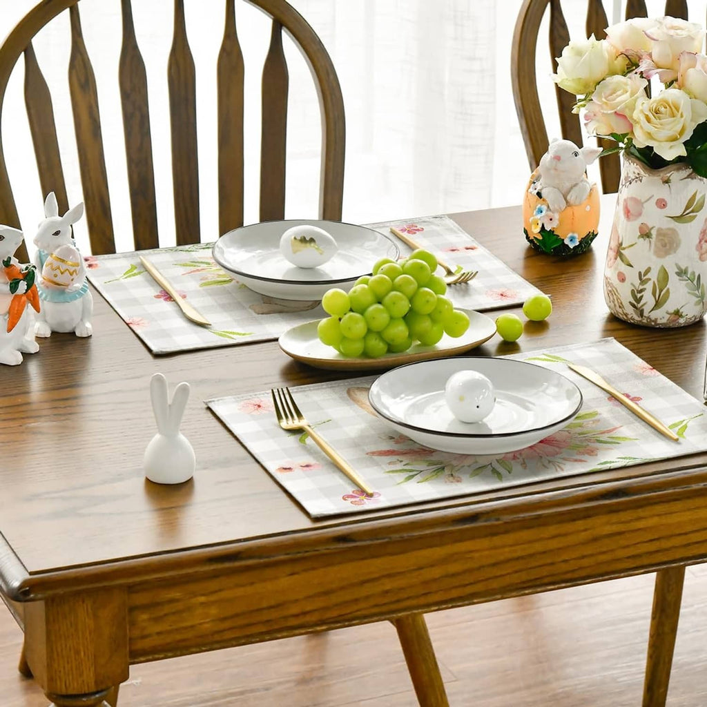 Beige plaid bunny-ear floral rectangular placemats arranged on a dining table.