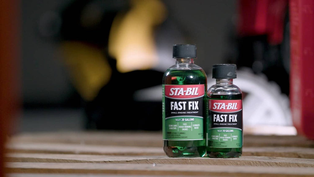 Two STA-BIL Fast Fix small engine treatment bottles on a wooden surface