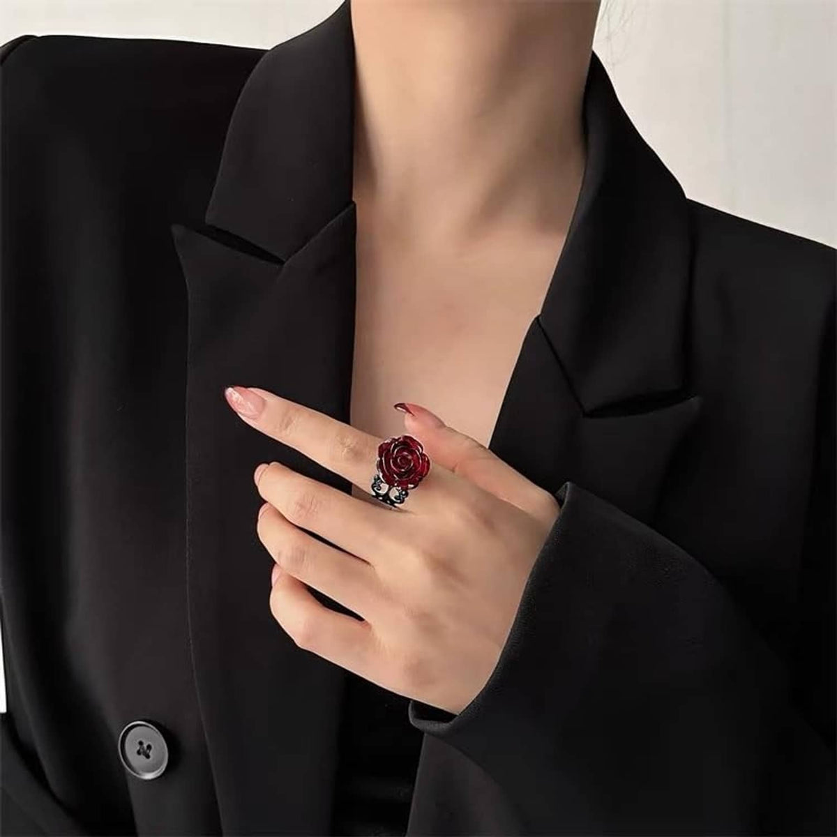 Dark red rose gothic ring with black scrollwork, adjustable, on manicured finger