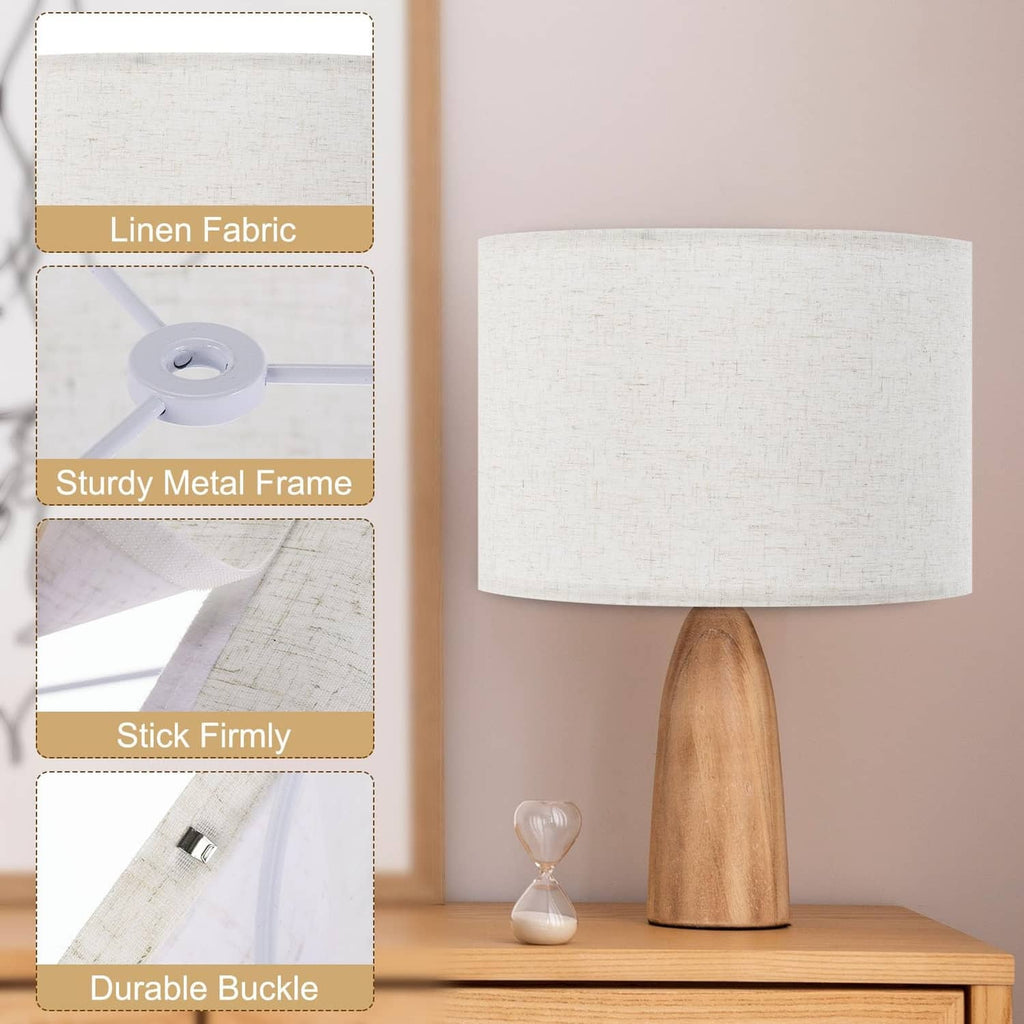 Beige linen drum lamp shade on metal base lamp; fabric-wrapped round shade