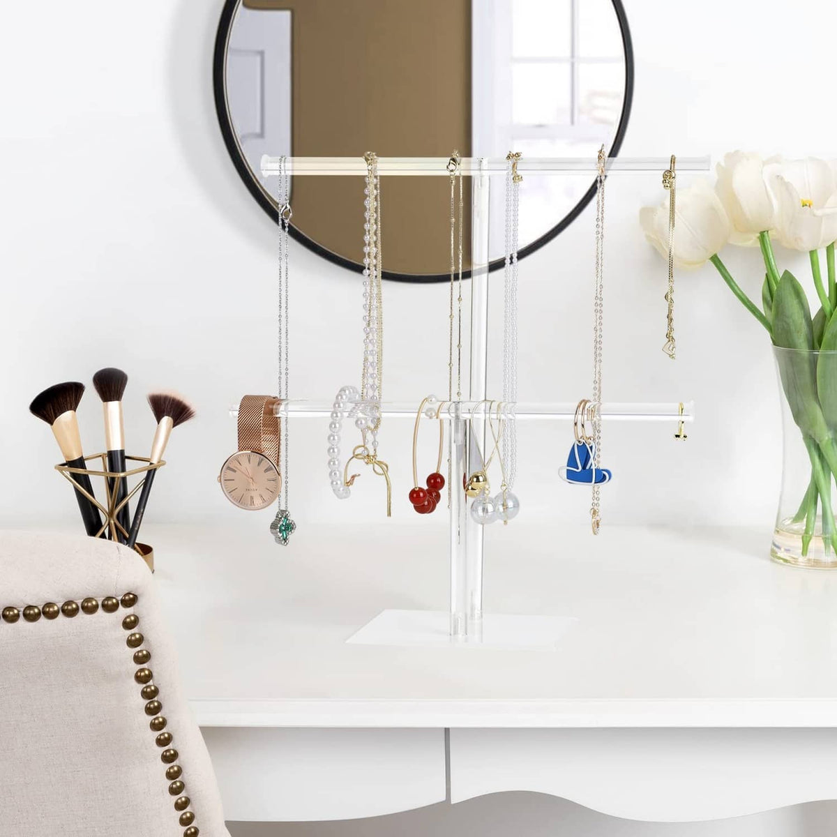 Clear acrylic jewelry stand with hanging necklace chains on horizontal bar