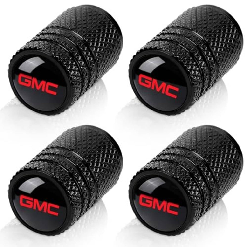Four black textured valve stem caps, each with red GMC logo end cap