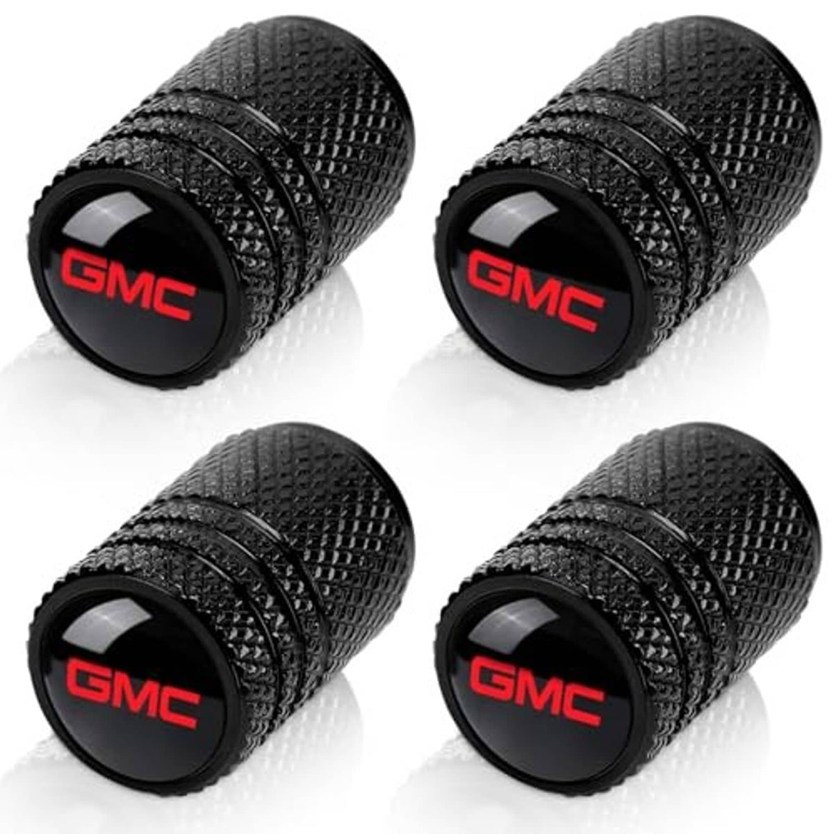Four black textured valve stem caps, each with red GMC logo end cap