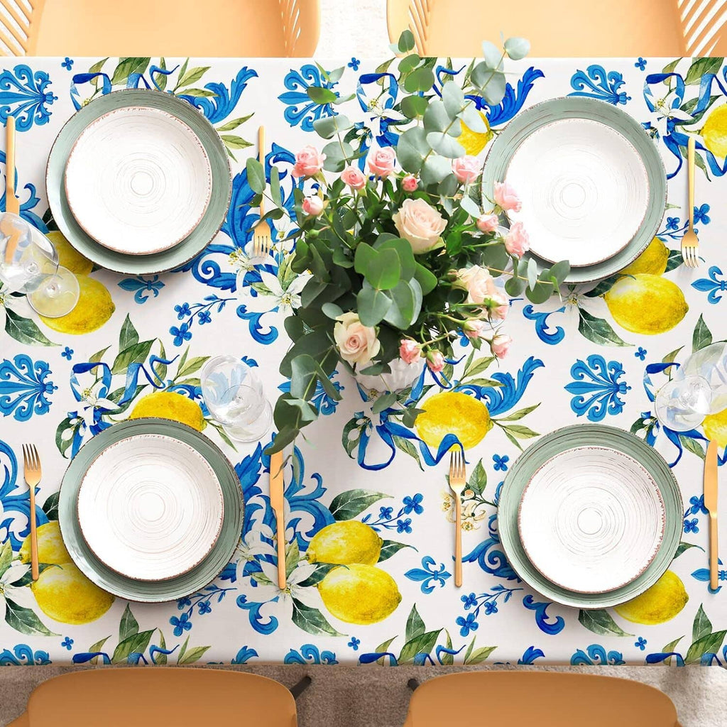 White tablecloth with blue baroque pattern and yellow lemons laid for table setting