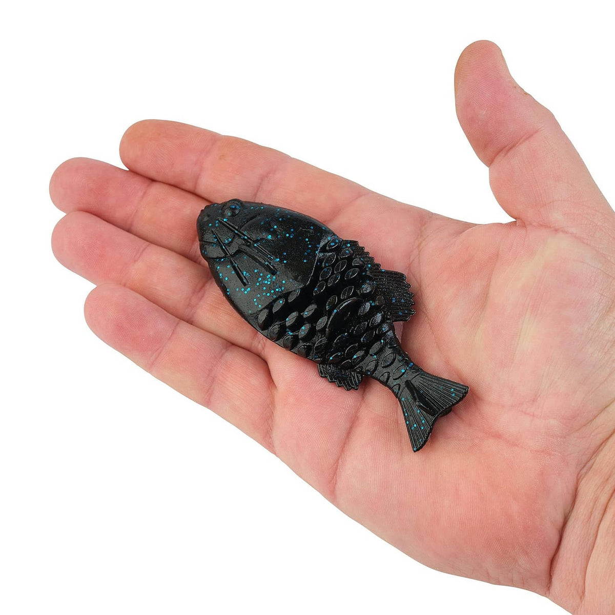 Black-and-blue fleck soft plastic fishing lure resting in an open hand.