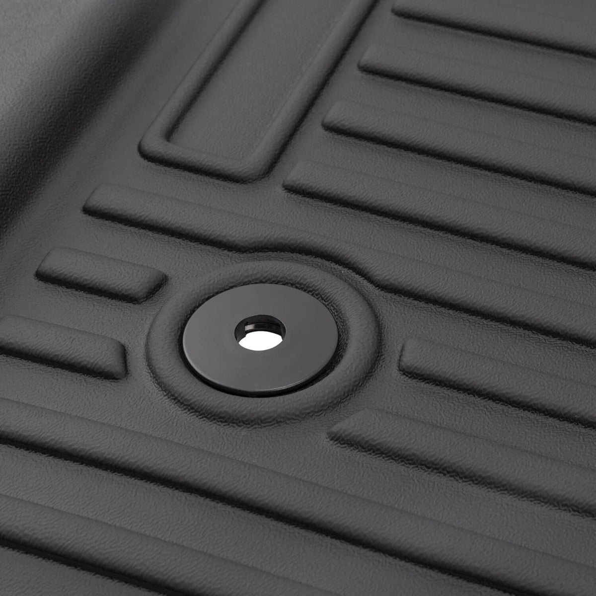 Close-up of black floor mat liner texture with round fastener opening