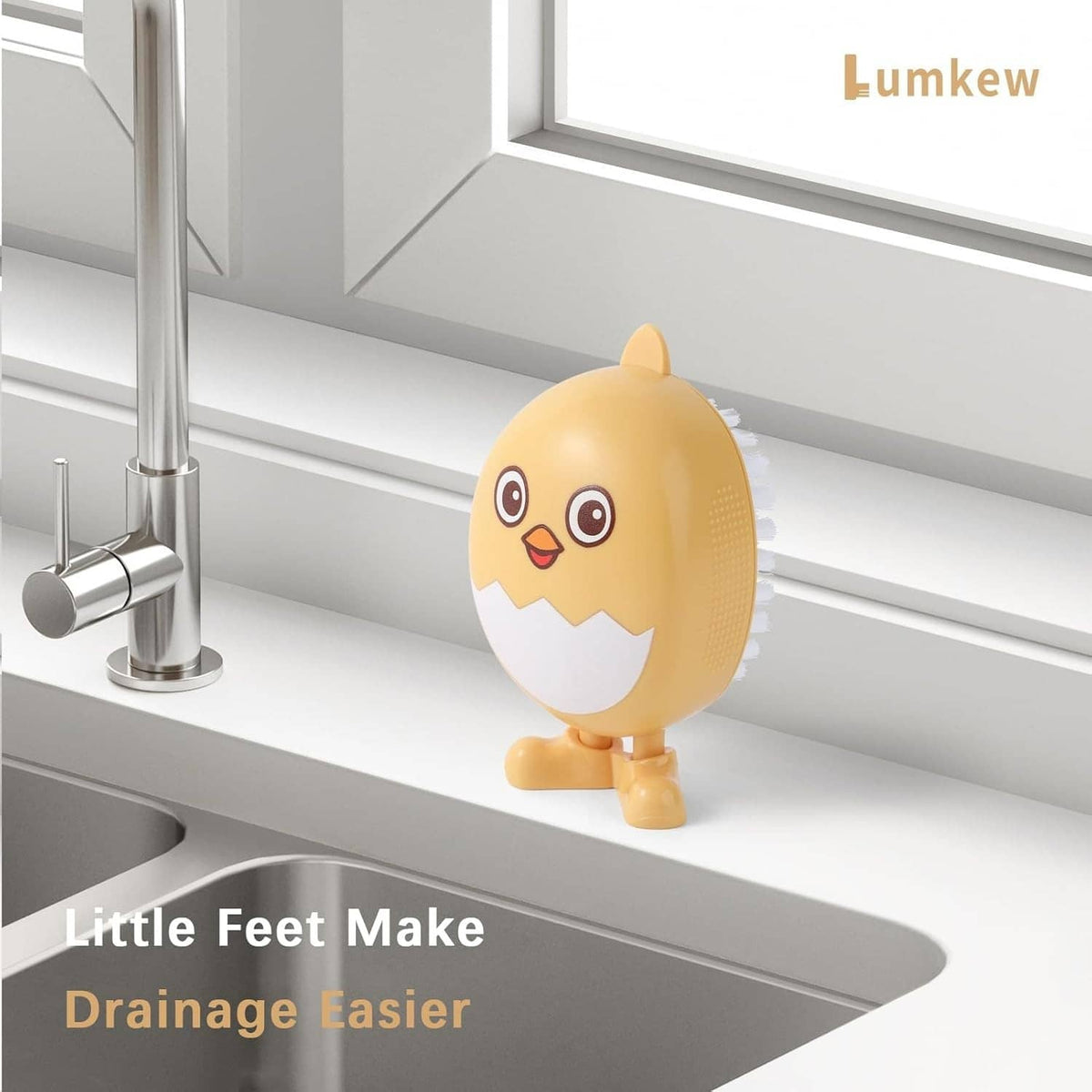 Yellow egg-shaped scrub brush with cartoon face on sink ledge near faucet