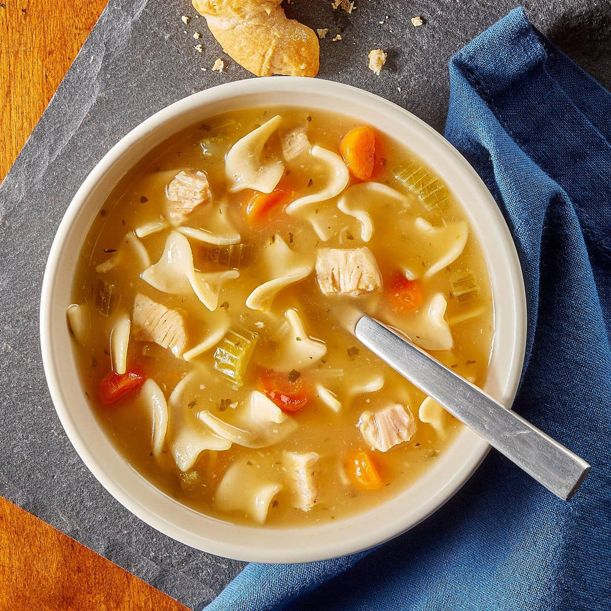 Bowl of chicken noodle soup with visible chicken, carrots, and noodles