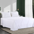 White oversized king flat sheet with draped folds over a bed mattress