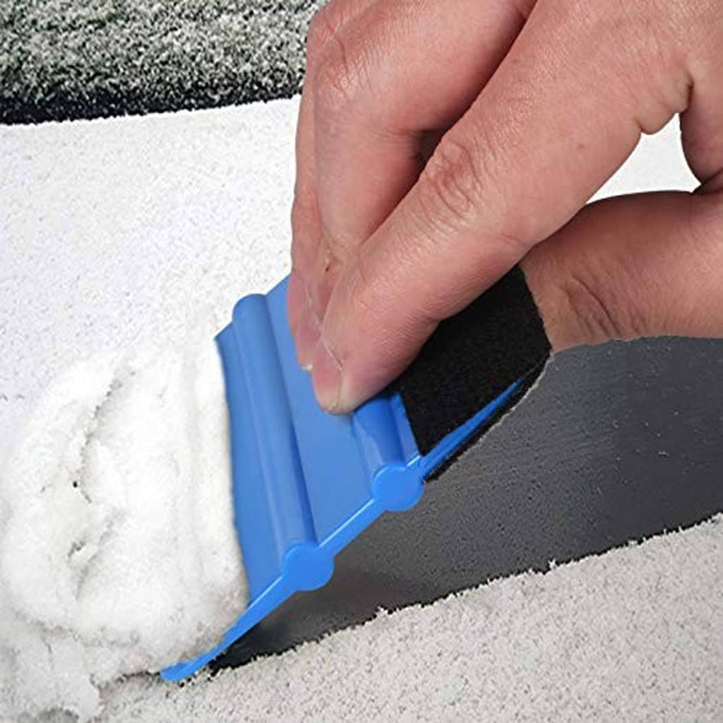 Blue felt edge squeegee with black felt pad, hand trimming along carpet edge