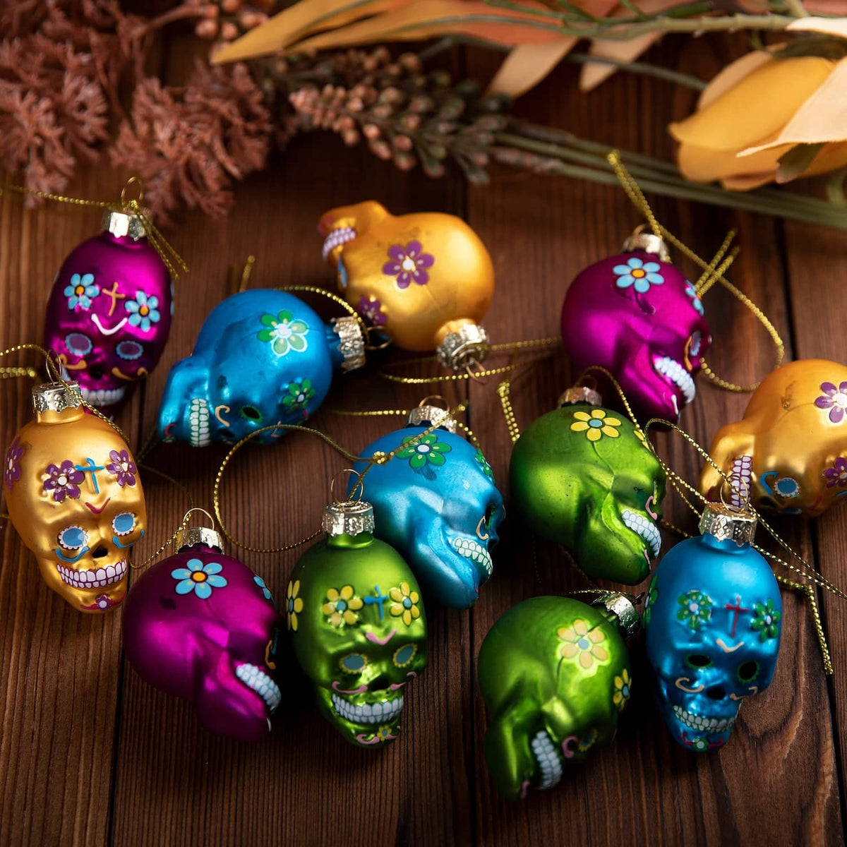 Assorted Day of the Dead glass skull ornaments with floral cross details, hanging