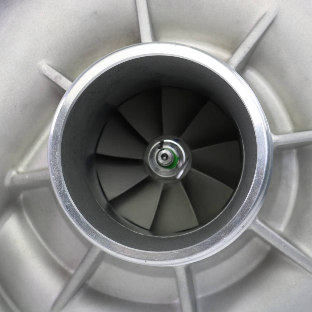 Turbocharger compressor wheel inside silver housing with six blades