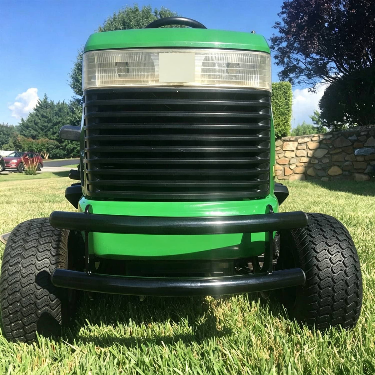 Black front bumper installed on a green lawn tractor with tubular guard
