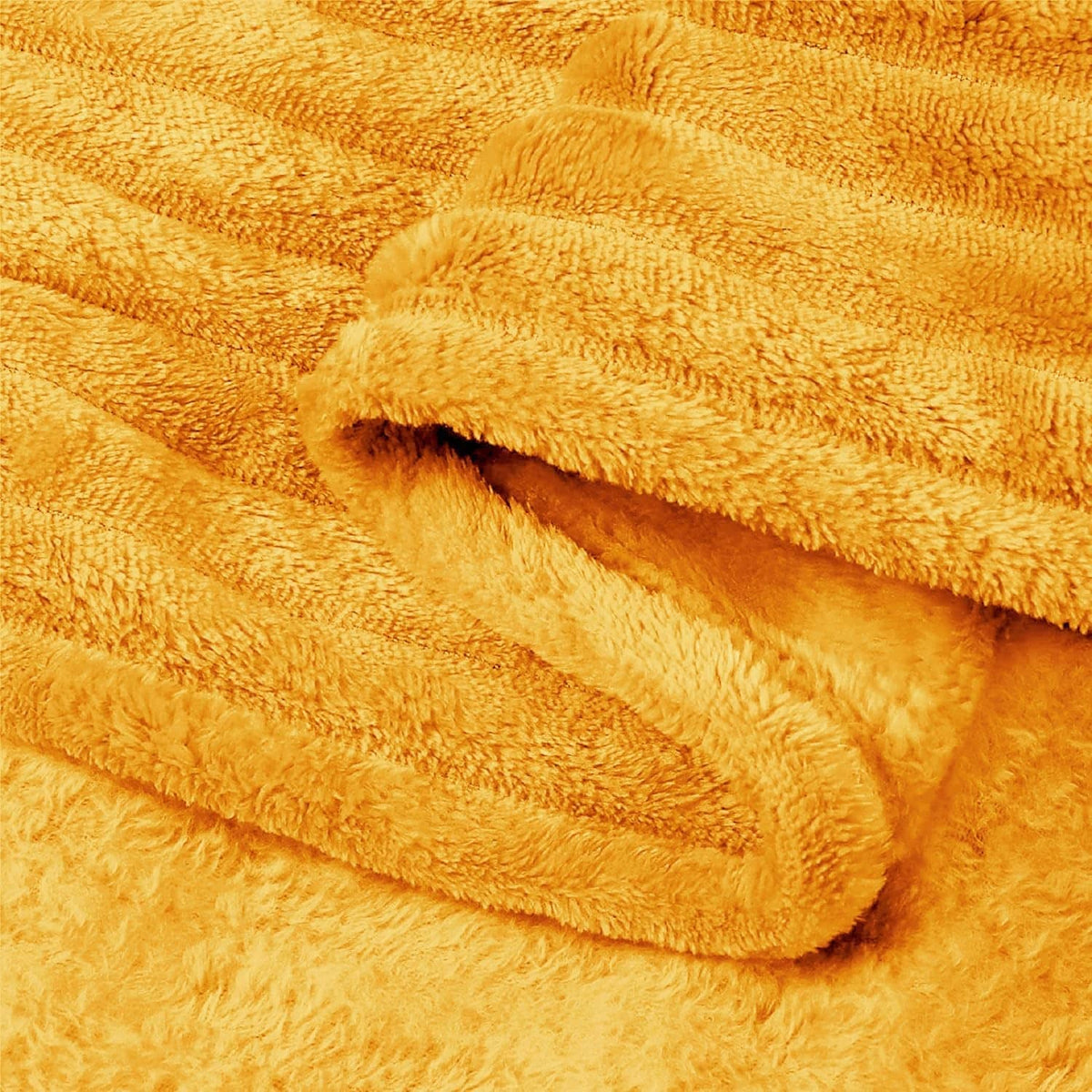 Yellow fleece blanket fabric close-up with plush pile and ribbed weave
