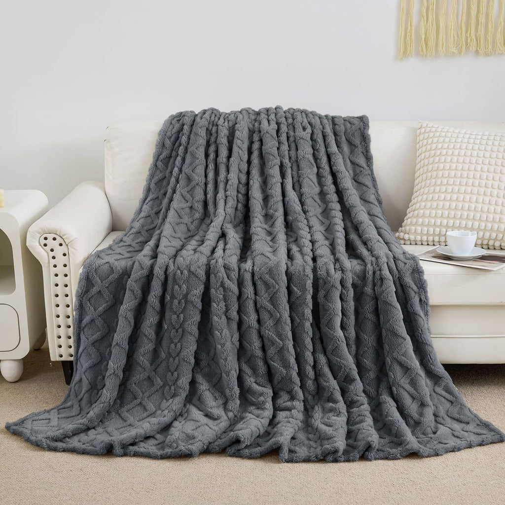 Gray fuzzy blanket on couch with thick raised vertical cable pattern