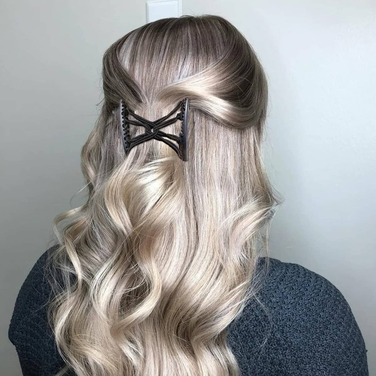 Black hair comb fork clip securing long wavy blonde hair at the crown