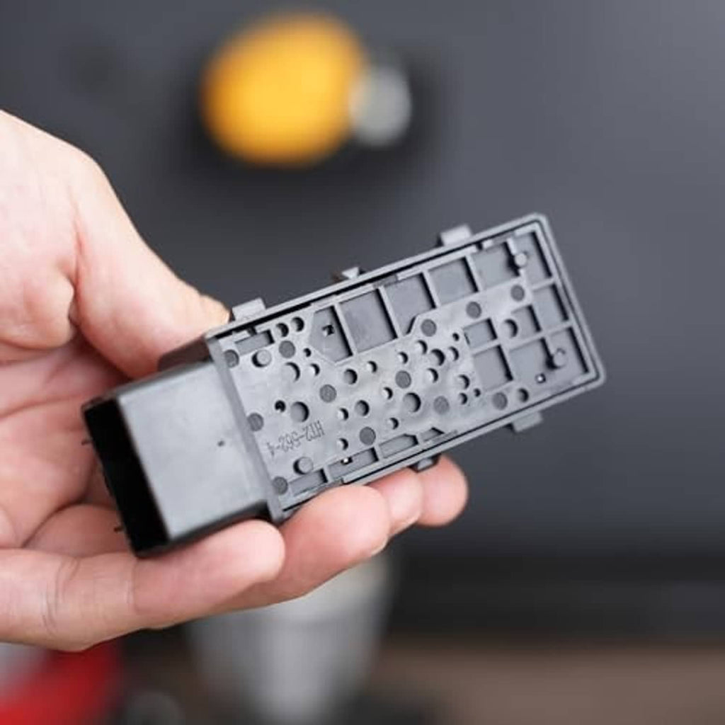 Power seat switch connector held in hand, underside metal plate with contact holes