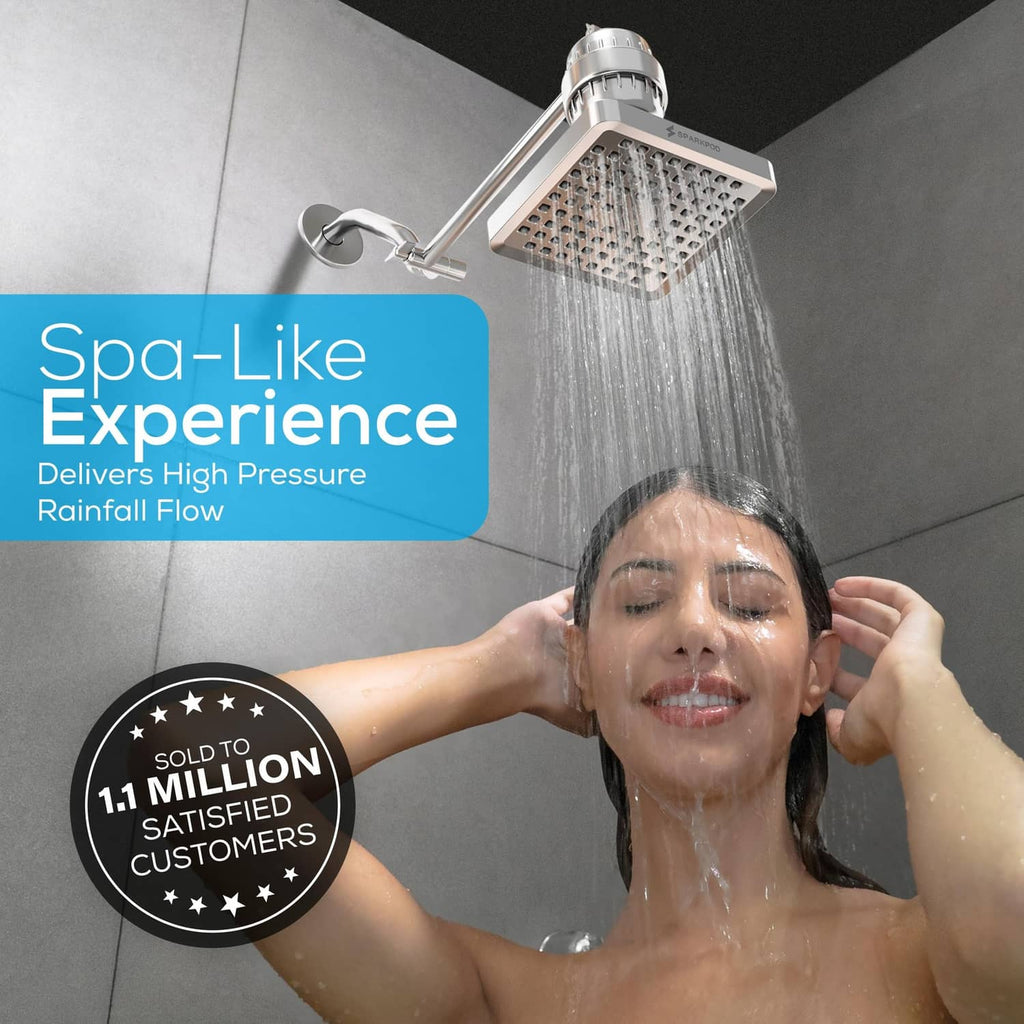 Polished chrome square rain shower head spraying water from multiple nozzles