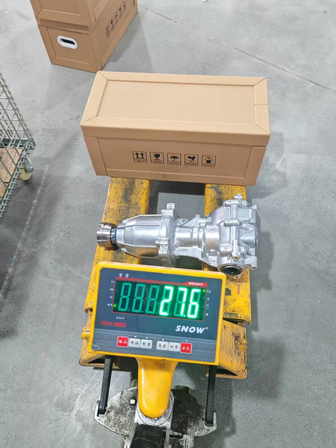 Rear differential assembly on a scale under a shipping box, with intake ports visible.