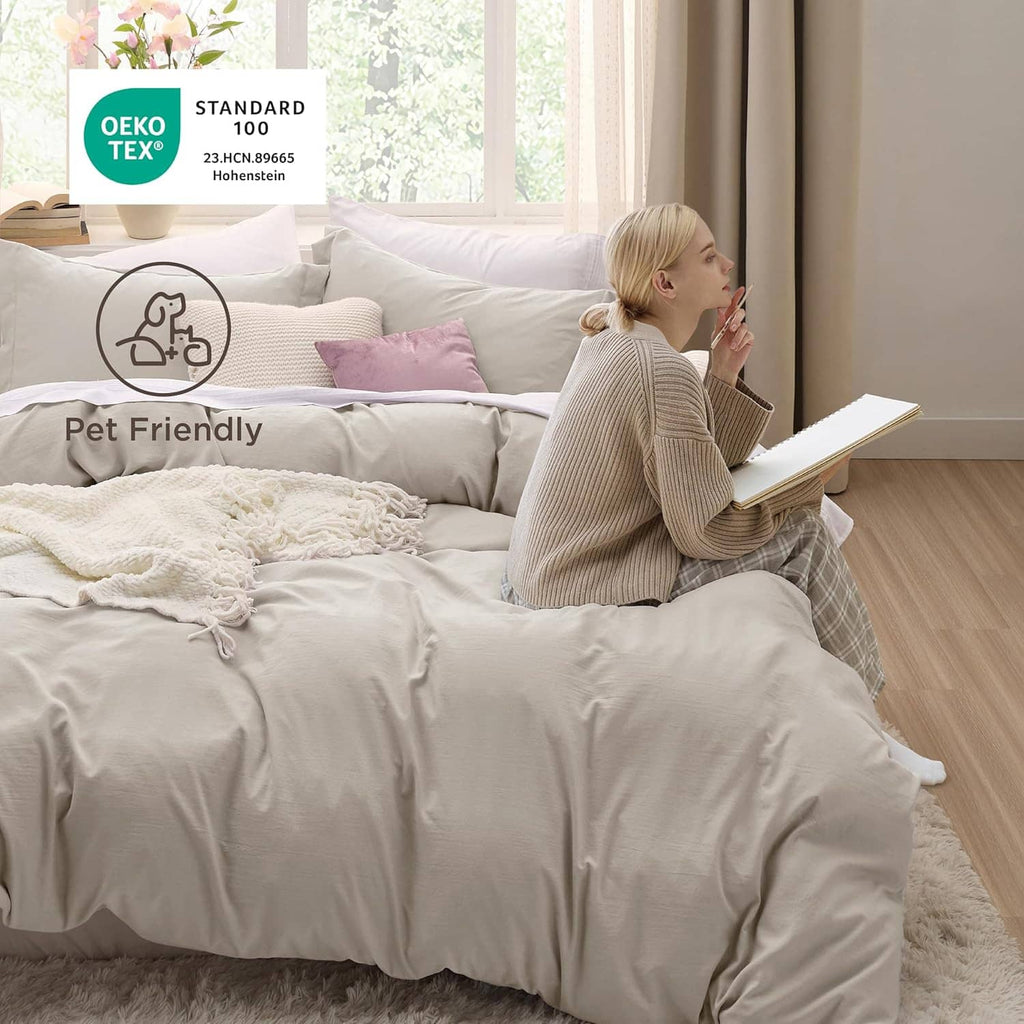 Queen duvet cover set in light beige with matching pillow shams on a neatly made bed
