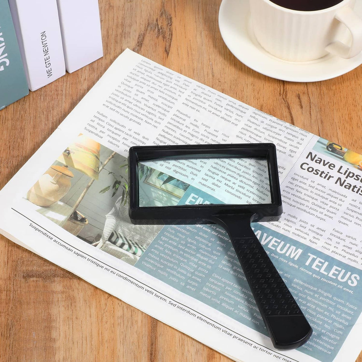 Black rectangular handheld reading magnifier over an open newspaper page