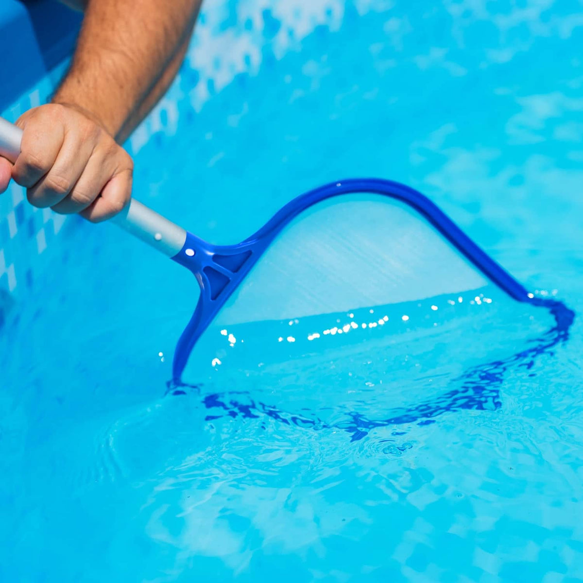 Light blue pool skimmer net in pool water with handle attached