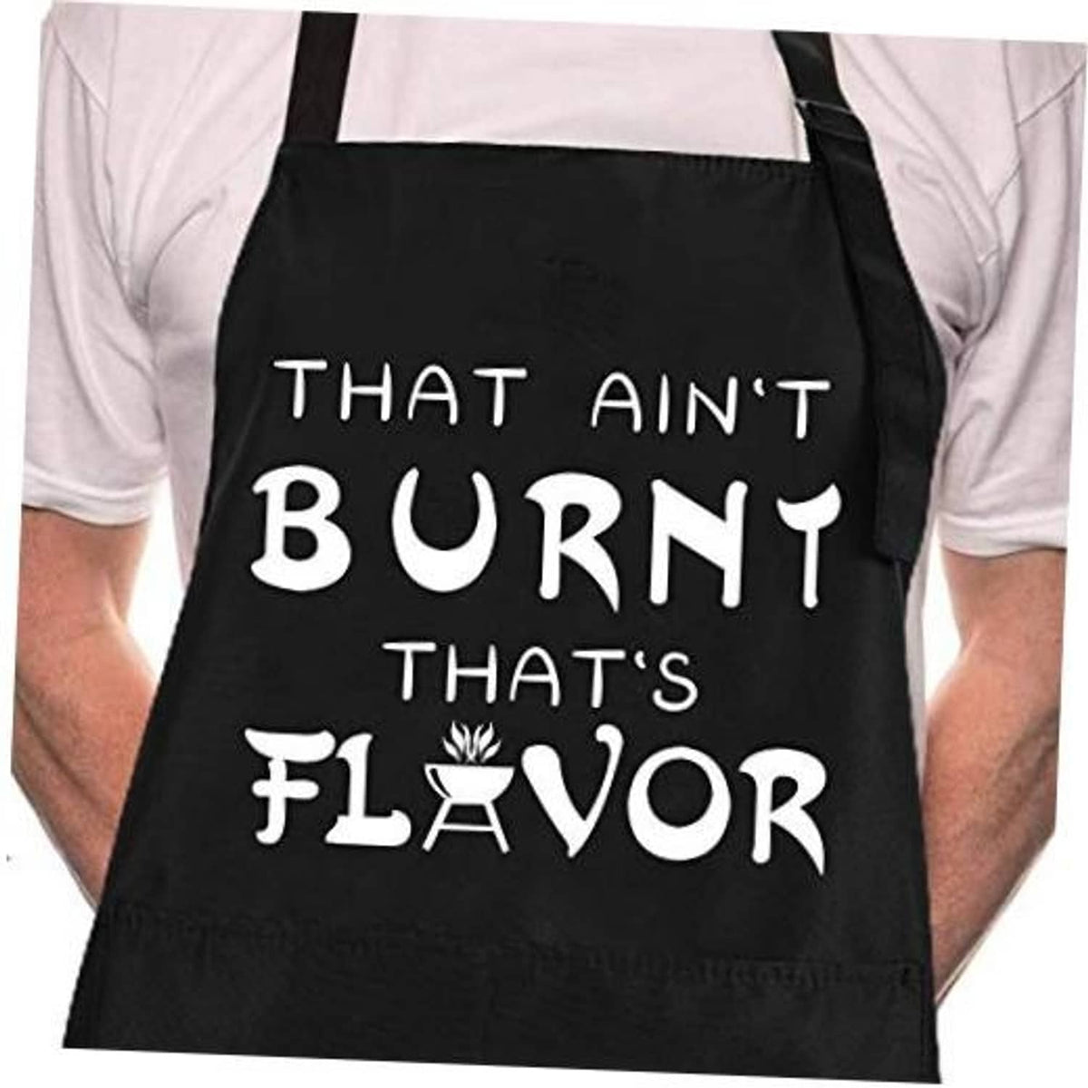 Black chef apron worn over a white shirt with large “That Ain’t Burnt That’s Flavor” print.
