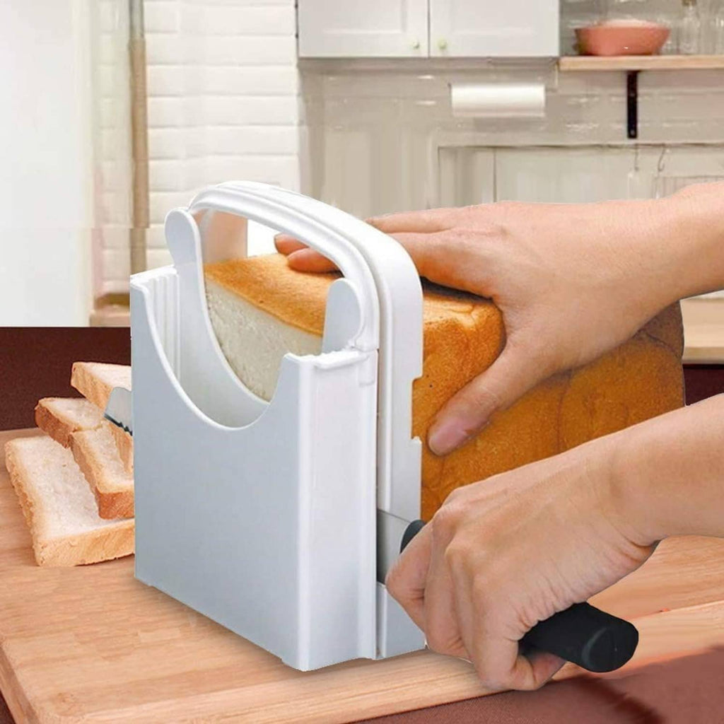 White bread slicer on a cutting board with hands preparing to slice a loaf