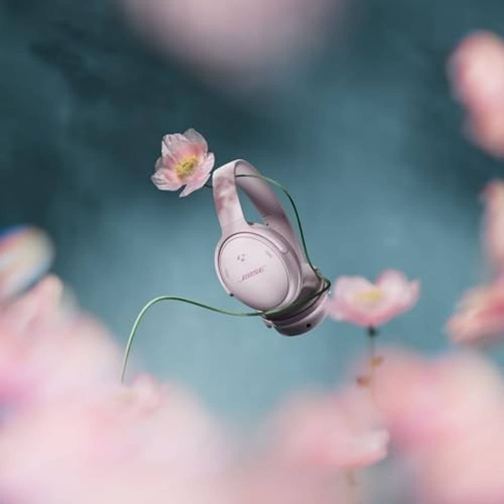 Pink wireless over-ear headphones with hanging cable and side earcup visible
