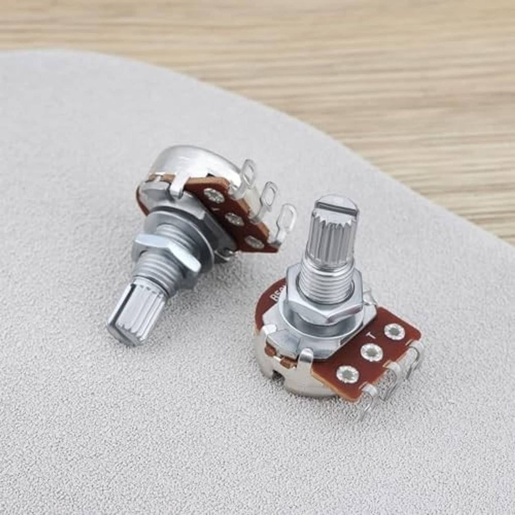 Two linear potentiometer knobs on tabletop, showing metal housings and brown contact bases