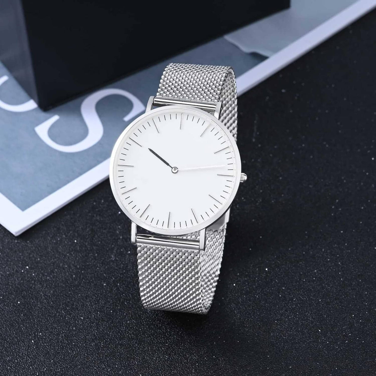 Silver mesh watch band on round white-dial watch with slim metal clasp