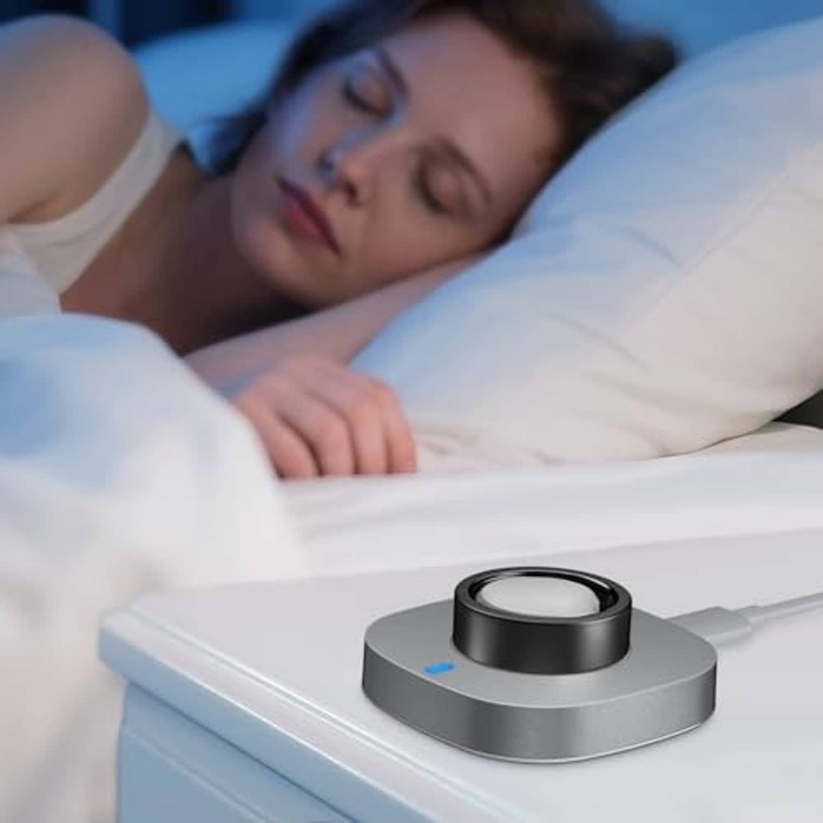 Grey ring charging dock with black cradle on a bedside table