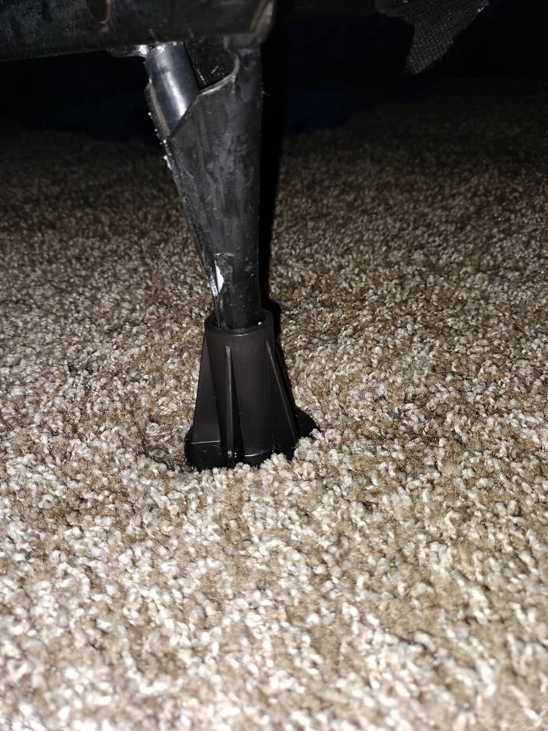 Bed frame foot replacement glide with steel stem and black base on carpet