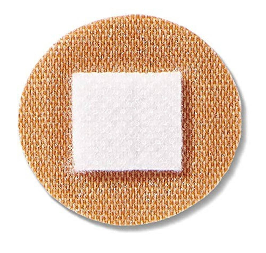 Round brown adhesive fabric bandage with white square non-stick pad