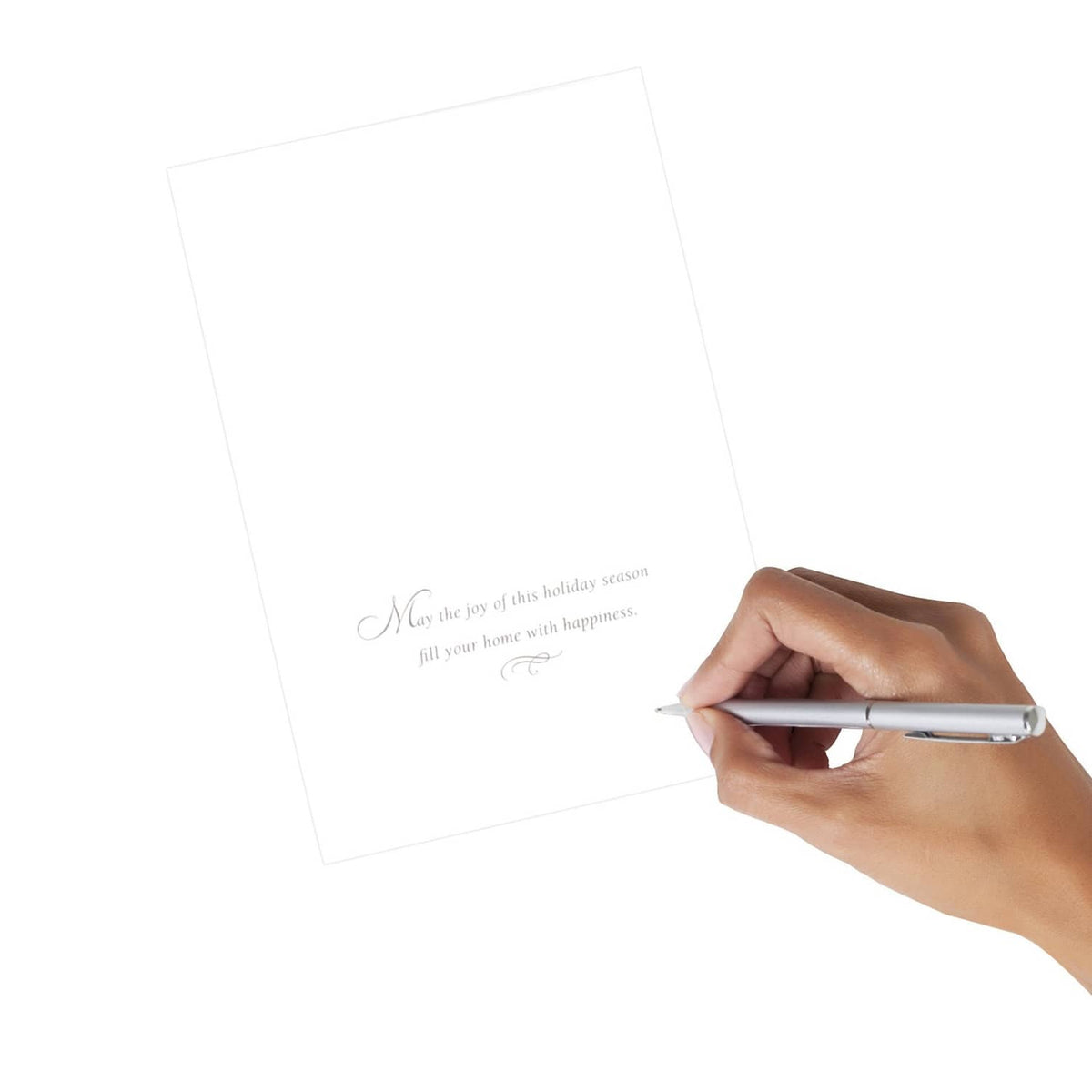 Blank Christmas card insert held at an angle with hand writing with a pen