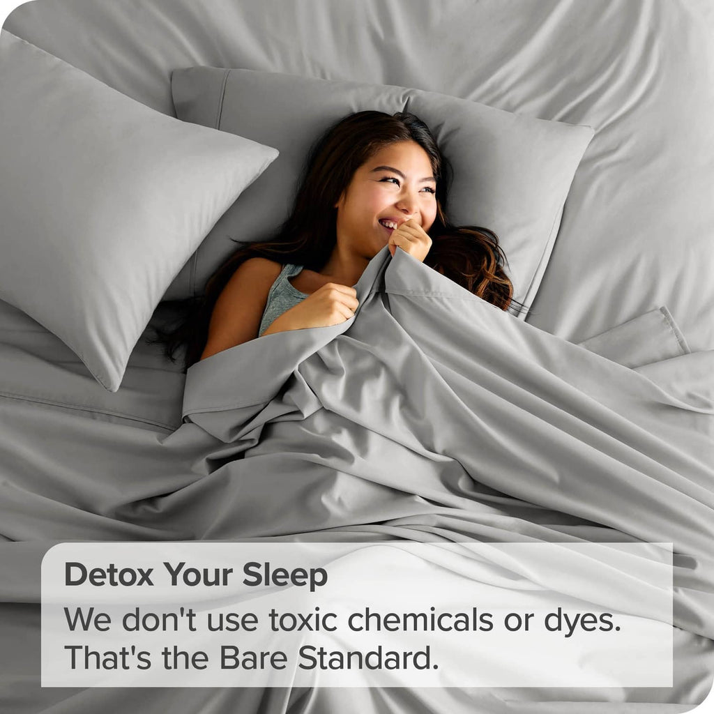 Light grey microfiber flat sheet on bed, partially covering a person