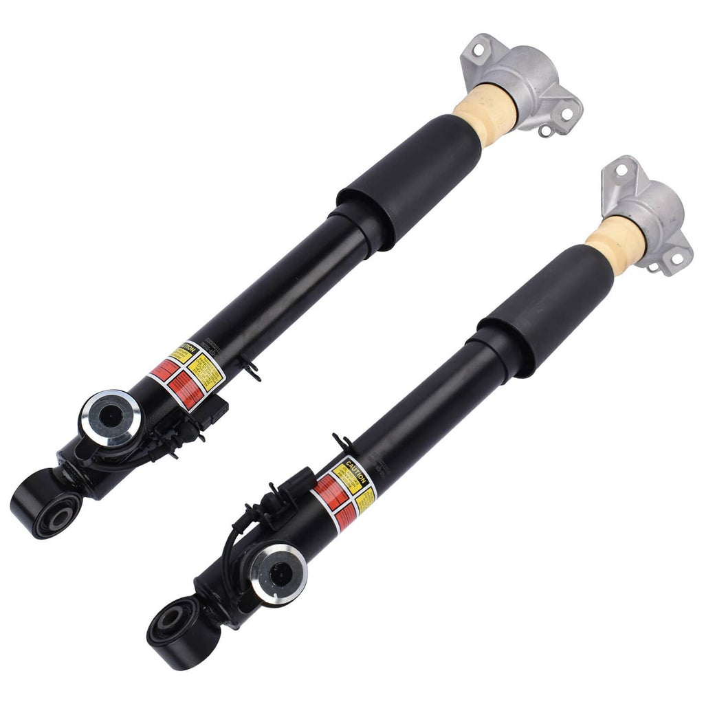 Pair of electronic shock absorbers with black bodies, beige damper tops, and link hardware.