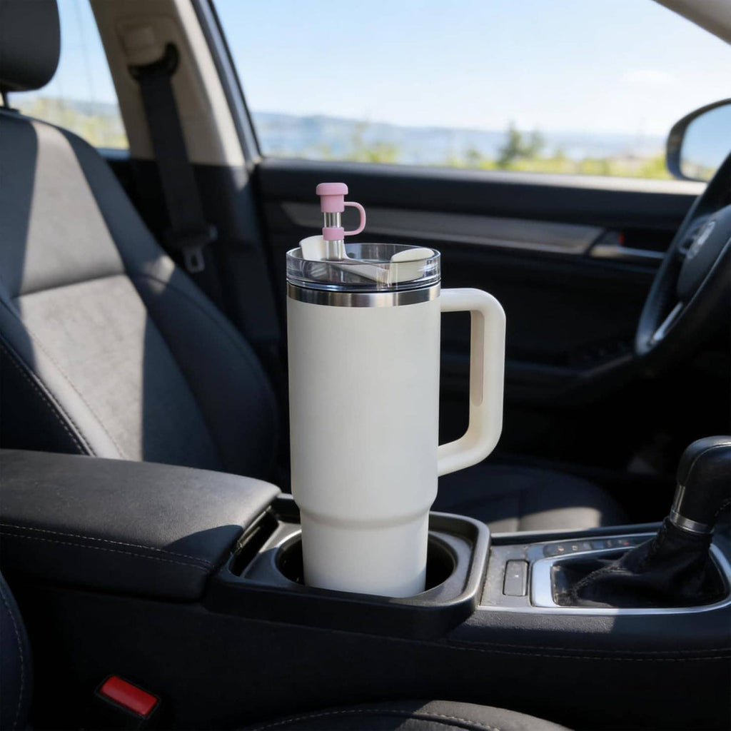 White tumbler with pink silicone straw cover topper, car cup holder