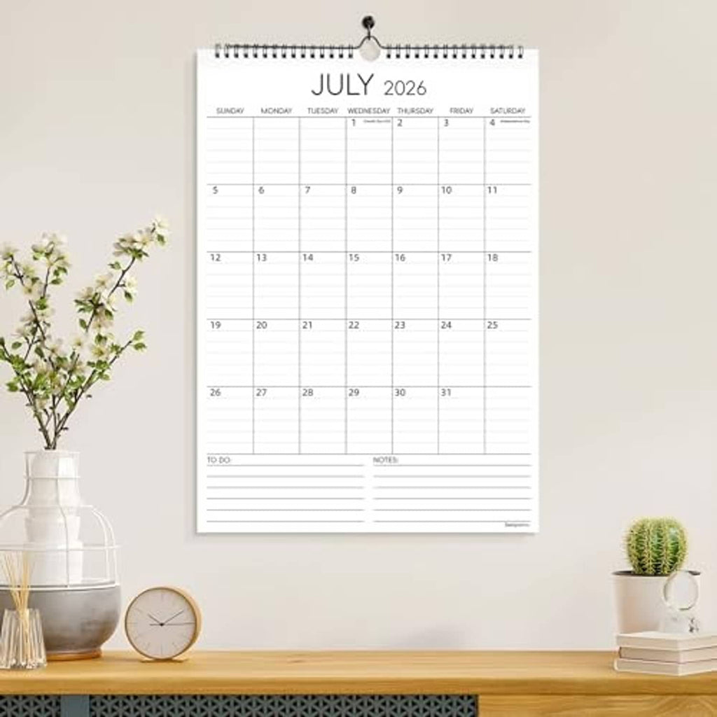 July 2026 wall calendar shown hanging with ring binding and date grid