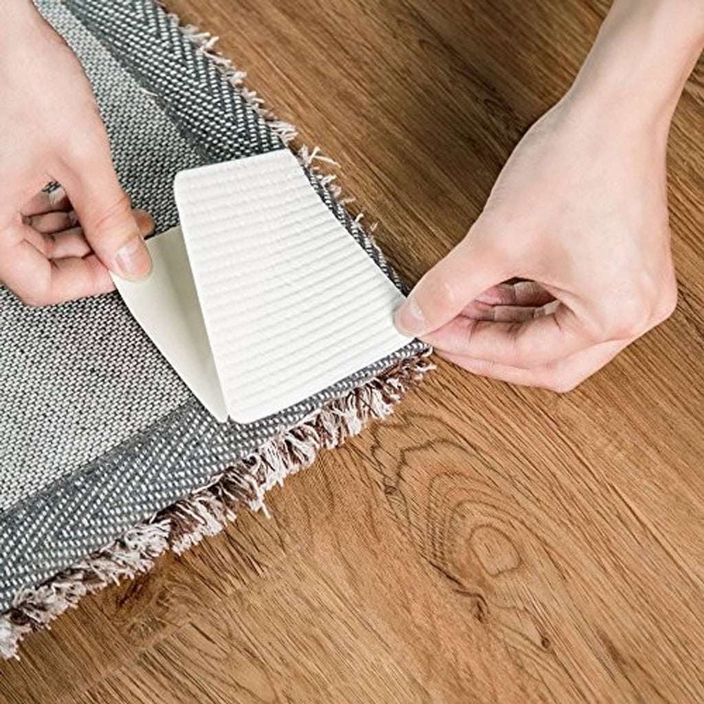 White non-slip backing strip of rug pad gripper peeled off near rug edge on wood