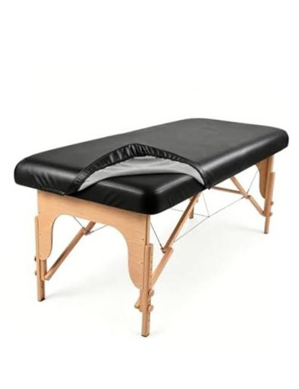 Black massage table cover with elastic side straps on wooden massage bed, arched head cutout