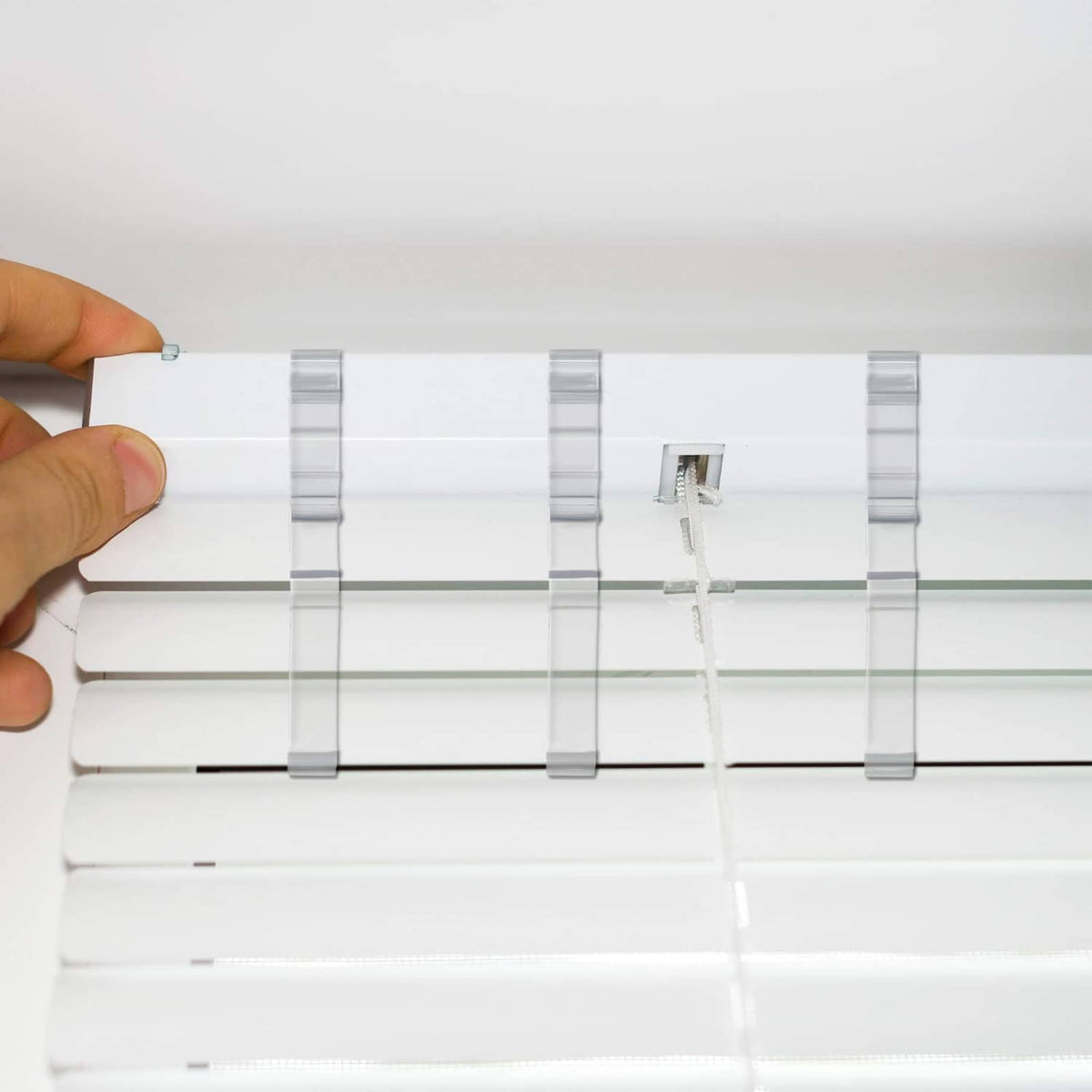 Clear plastic valance clips attached to a curtain rod and valance fabric